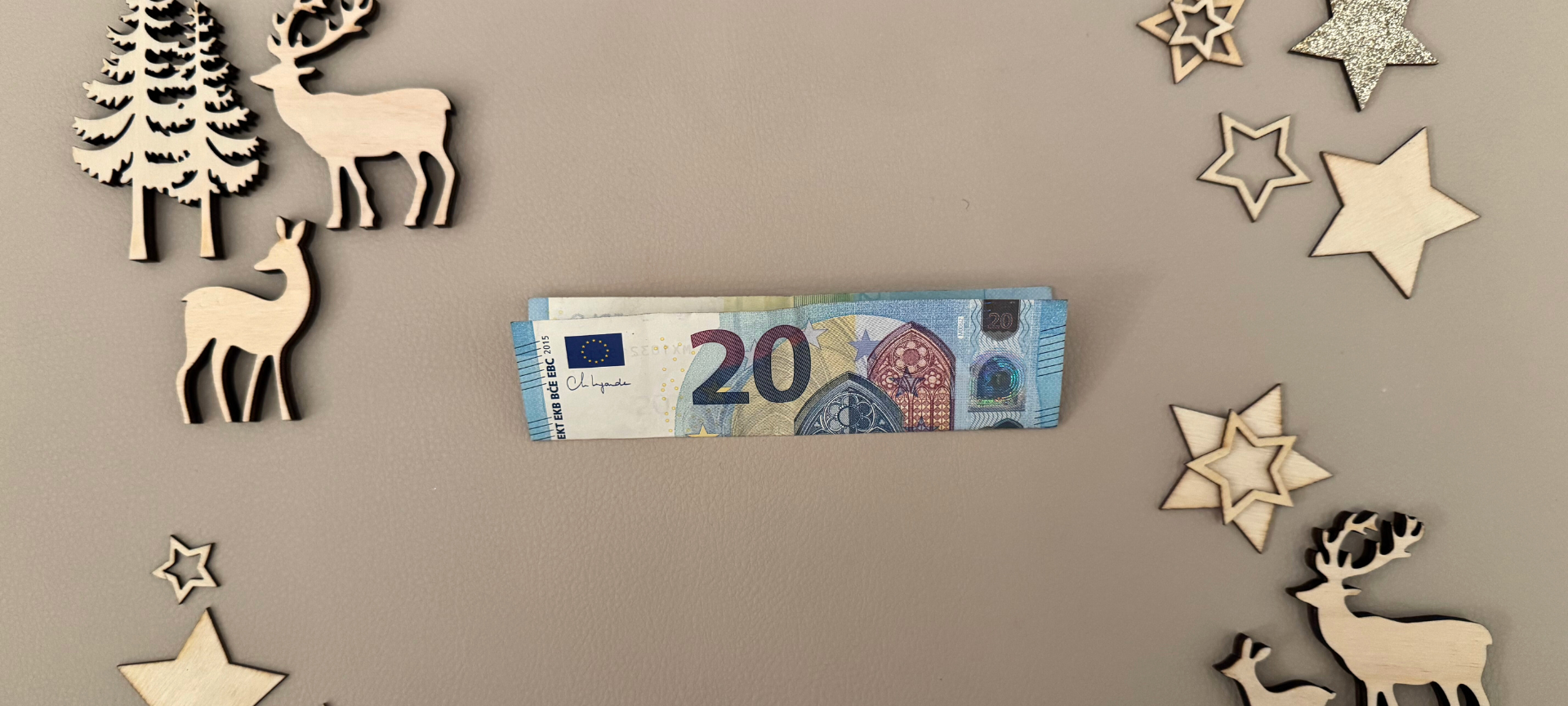 1. Geldschein querlegen und in der Mitte nach oben falten.